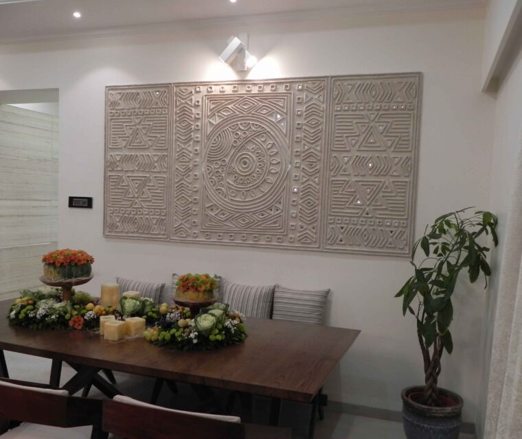 Dining room with carved wall art panel and indoor plant, contemporary decor
