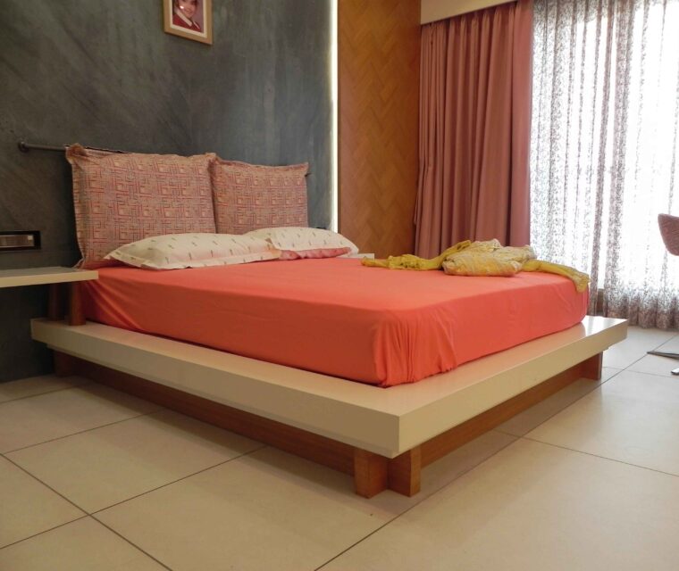 Modern platform bed design with accent wall and pink bedding