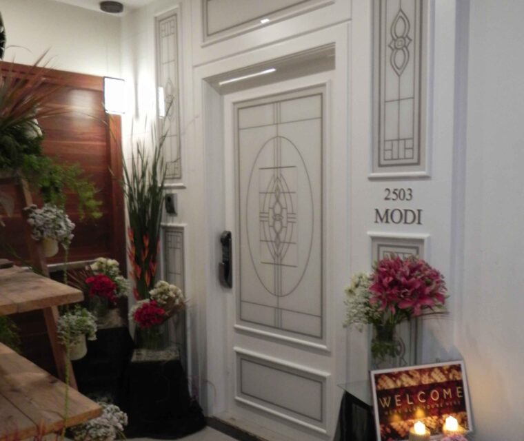 Welcoming apartment entrance decorated with flowers and designer nameplate