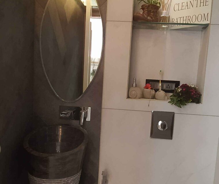 Designer bathroom with vertical basin, wall mirror, and smart decor