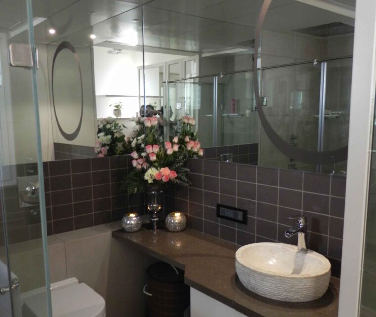 Stylish bathroom interior with designer wash basin and floral decoration