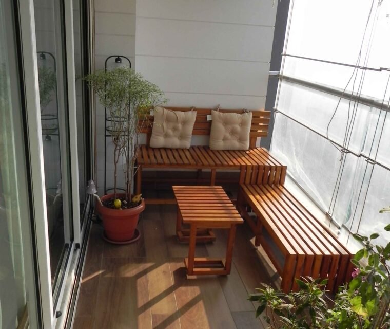 Cozy balcony seating with wooden benches and potted plants, apartment decor
