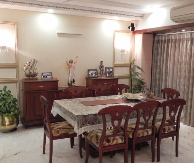 Formal dining room design with wooden table set, lace tablecloth, and elegant lighting