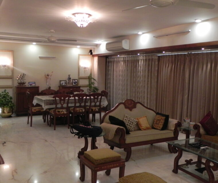 Spacious living and dining area with wooden sofas and wall decor art