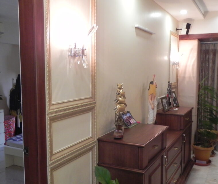 Classic living and dining space with wooden furniture, indoor plants, and showcase