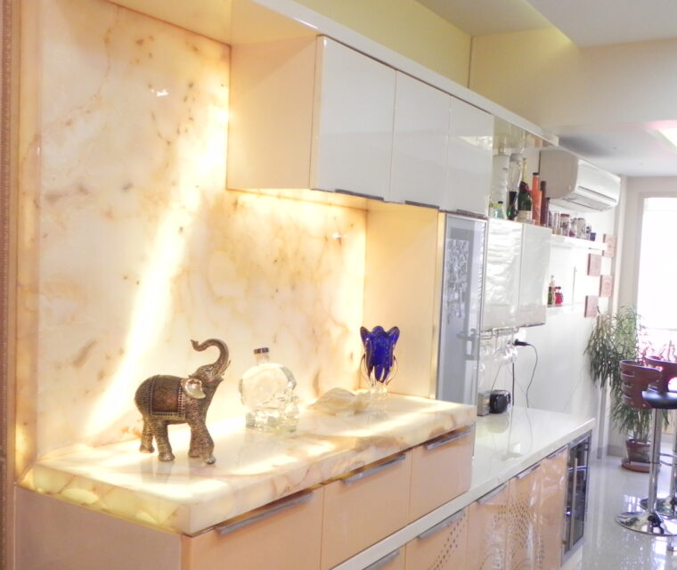 Luxury modular kitchen interior with white high gloss cabinets and onyx backsplash lighting