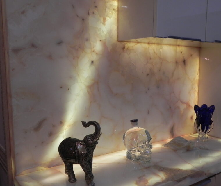 Onyx marble kitchen counter and backsplash with decorative elephant and crystal bottle