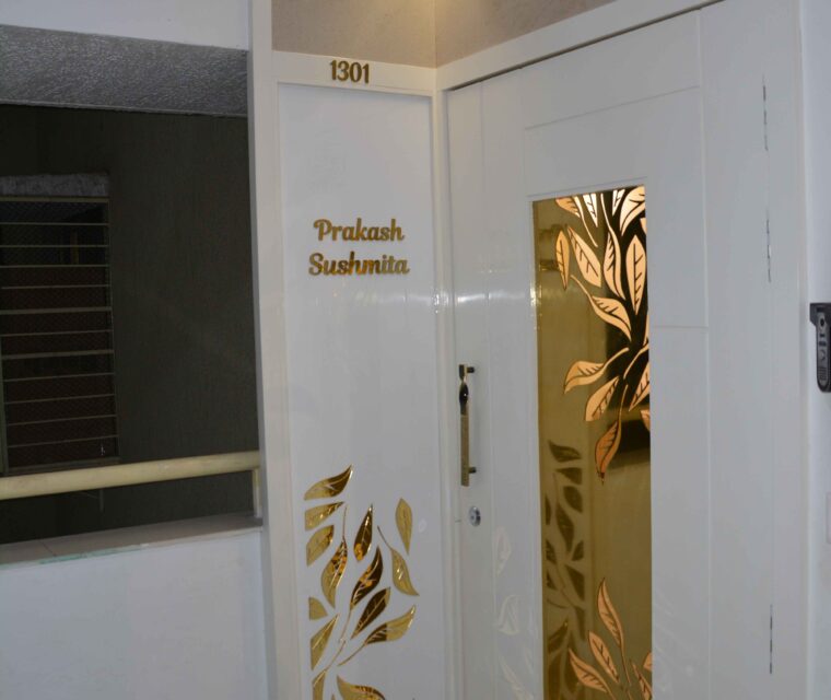 Elegant apartment main door with white and gold designer elements and custom nameplate