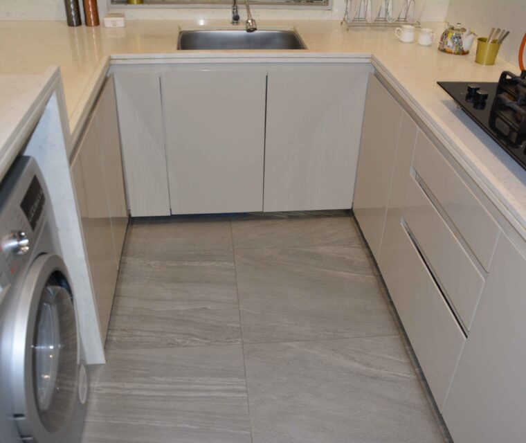 L-shaped kitchen counter with under-sink storage and seamless cabinet finish