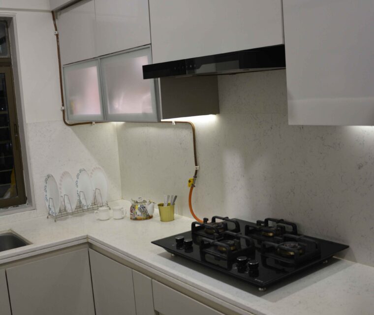 Modular kitchen interior with built-in gas stove, sleek cabinets, and LED lights