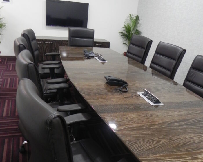 Modern corporate conference room interior with executive seating, sleek wooden table, and contemporary lighting design