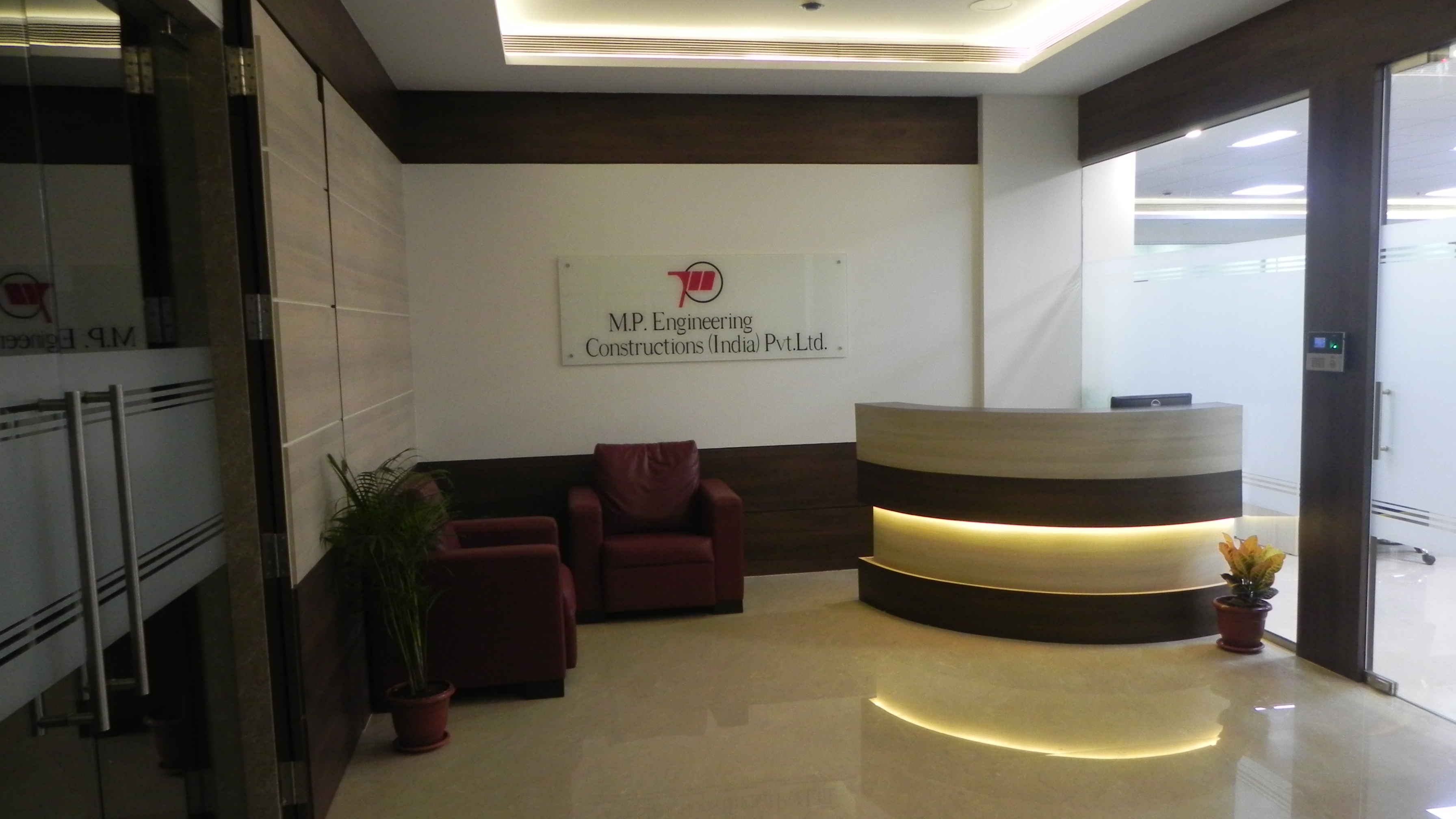 Stylish reception area interior at M.P. Engineering office with branded logo and designer lighting