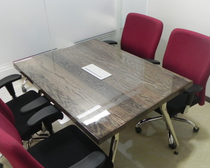 Corporate open plan office interior design featuring maroon chairs and collaborative workspace