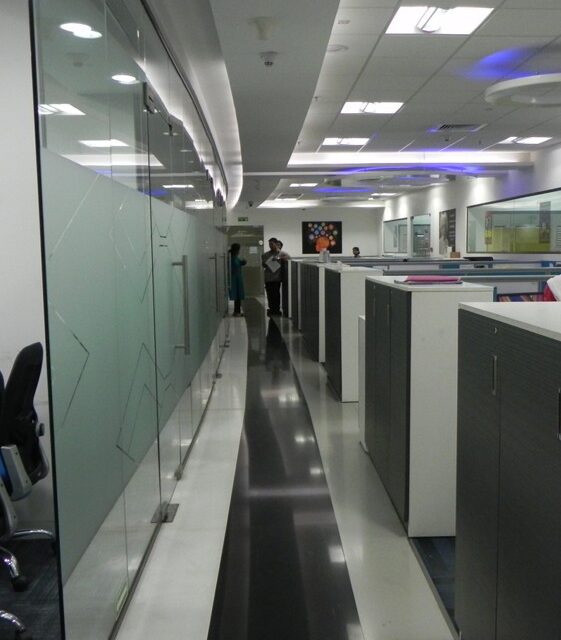 Modern office interior with glass partitions and open workstations in a corporate workspace
