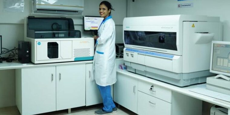 Advanced medical lab with automated testing machines, computer setup, and professional technician – healthcare laboratory interior setup