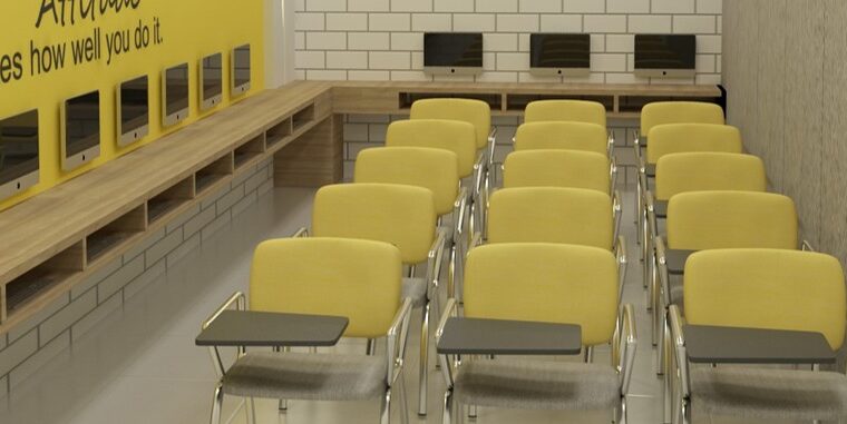 Training room interior with yellow chairs, computer workstations, and motivational wall decor for educational institute