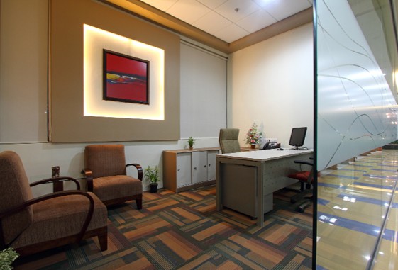 Office reception area with designer sofa, decorative plants, and geometric flooring – welcoming corporate lobby interior design