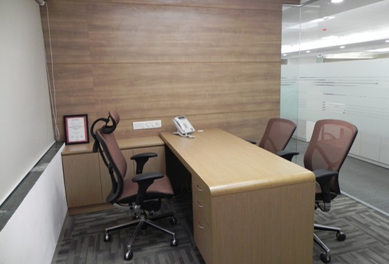 Private executive office interior with ergonomic chairs, wooden desk, and modern décor design